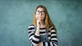 Thoughtful student girl on green chalkboard