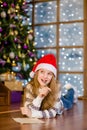 Thoughtful teen girl in red christmas hat writes letter to Santa Claus Royalty Free Stock Photo