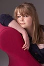 Thoughtful Teenage Girl Relaxing On Chaise Longue