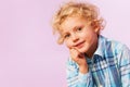 Thoughtful thinking blond curly hair boy portrait