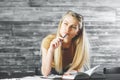 Thoughtful woman with book doing paperwork Royalty Free Stock Photo