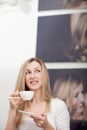 Thoughtful woman drinking a cup of tea