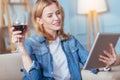 Thoughtful woman drinking wine while holding a modern tablet Royalty Free Stock Photo