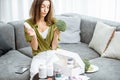 Thoughtful woman with nutritional supplements and broccoli at home Royalty Free Stock Photo