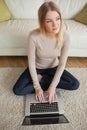 Thoughtful woman sitting on floor using laptop Royalty Free Stock Photo