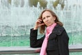 Thoughtful woman standing near a fountain