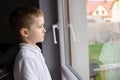 Thoughtful 6 year old boy looking out the window Royalty Free Stock Photo