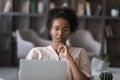 Pensive African American woman work on laptop thinking