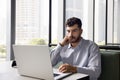 Thoughtful young Arab manager man working at laptop