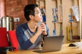 Thoughtful young asian man using laptop in cafe Royalty Free Stock Photo