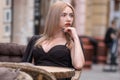 Thoughtful young attractive business woman sitting at table in cafe in black suit and waiting Royalty Free Stock Photo