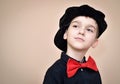 Thoughtful young boy with red bow tie and black shirt and cap Royalty Free Stock Photo