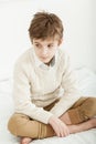 Thoughtful young boy sitting on his bed Royalty Free Stock Photo