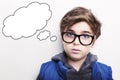 Thoughtful young boy wearing glasses with an empty thought bubble Royalty Free Stock Photo