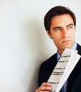 Thoughtful young business man holding a newspaper. Portrait of a thoughtful young business man holding a newspaper with Royalty Free Stock Photo