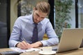 Thoughtful young business man writing something down while working in modern office Royalty Free Stock Photo