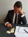 thoughtful young businessman analyzing budget and Swiss money on the table