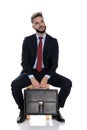 Thoughtful young businessman holding suitcase and thinking Royalty Free Stock Photo