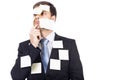 Thoughtful young businessman with post-it notes on his face and Royalty Free Stock Photo