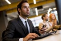 Thoughtful young businessman working in the modern office and connecting to wireless via computer Royalty Free Stock Photo