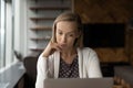 Pensive female employee work on computer in office