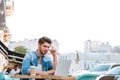 Thoughtful young casual man looking at laptop in cafe outdoors Royalty Free Stock Photo