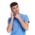 Thoughtful young casual man talking on the phone looks up Royalty Free Stock Photo