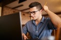 Thoughtful young caucasian businessman in glasses working on laptop computer. Pensive attractive hipster freelancer Royalty Free Stock Photo