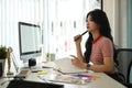 Thoughtful young female creative designer thinking, solving problem and review project at her workplace Royalty Free Stock Photo