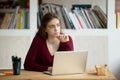 Thoughtful young female entrepreneur in front of laptop. Royalty Free Stock Photo