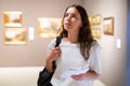 Thoughtful young girl in an art gallery studies works of art Royalty Free Stock Photo