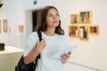 Thoughtful young girl in an art gallery studies works of art Royalty Free Stock Photo