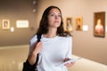 Thoughtful young girl in an art gallery studies works of art Royalty Free Stock Photo