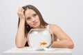 Thoughtful young girl looking at goldfish in a fishbowl Royalty Free Stock Photo