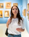 Thoughtful young girl in an art gallery studies works of art Royalty Free Stock Photo