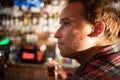 Thoughtful young man drinking beer at the bar counter Royalty Free Stock Photo