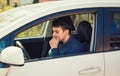 Thoughtful young man driver holding his hand under chin looking anxious waiting in his car Royalty Free Stock Photo