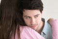 Thoughtful young man embracing lady looking away, lost in though Royalty Free Stock Photo