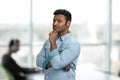 Thoughtful young man holding hand under chin. Royalty Free Stock Photo