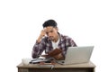 Thoughtful young man holding pen looking at notepad while sitting at his working place. Royalty Free Stock Photo