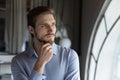 Thoughtful young man leader looking at window visualizing business opportunities Royalty Free Stock Photo