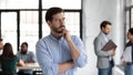 Thoughtful young man leader standing pondering in office workspace Royalty Free Stock Photo