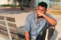 Thoughtful young man looking away while sitting in the park Royalty Free Stock Photo