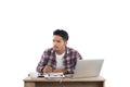 Thoughtful young man looking away while writing sitting at his Royalty Free Stock Photo