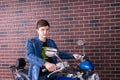 Thoughtful young man sitting on a motorbike Royalty Free Stock Photo