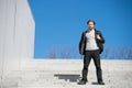 Thoughtful young man sitting on steps against blue sky background Royalty Free Stock Photo