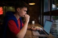 Thoughtful young man skilled freelance writer looking on laptop computer Royalty Free Stock Photo