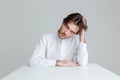 Thoughtful young man in white shirt sitting at the table Royalty Free Stock Photo