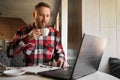 thoughtful young man working on laptop, drinking coffee while sitting in cafe. buisnessman surfing the net on laptop in Royalty Free Stock Photo