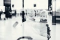 Thoughtful young mother looking trough window holding his infant baby boy child while waiting to board an airplane at Royalty Free Stock Photo